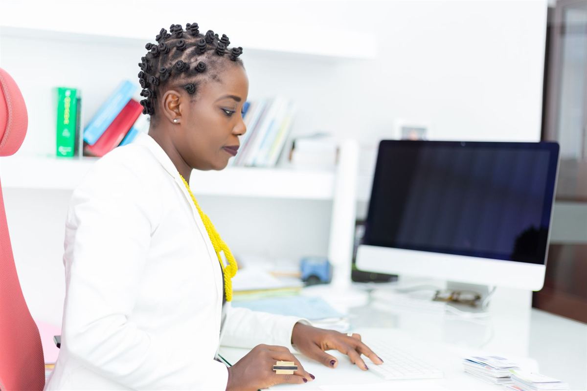 African woman working at a computer in a bright office