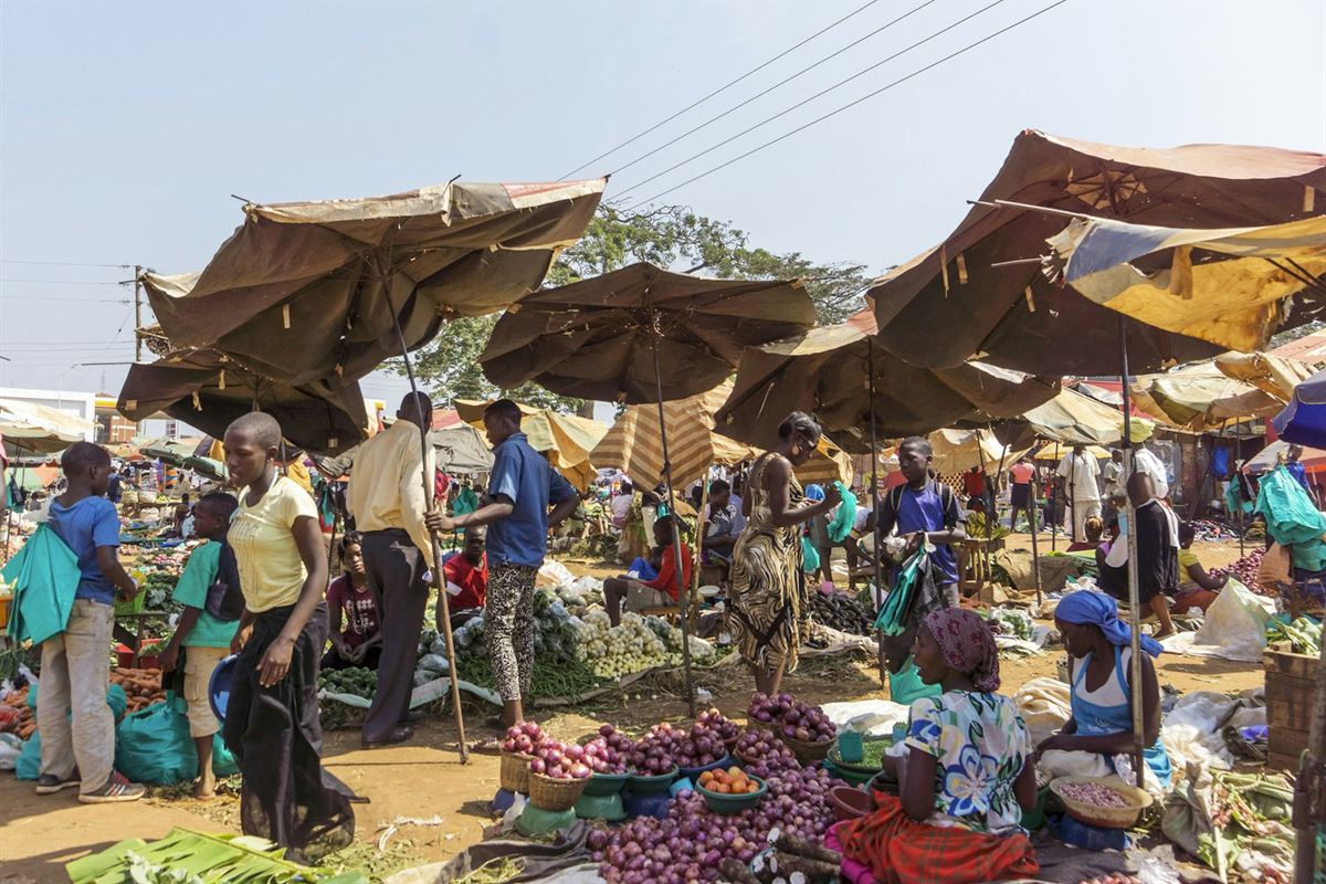 Busy outdoor market with vendors and shoppers in Entebbe, Uganda