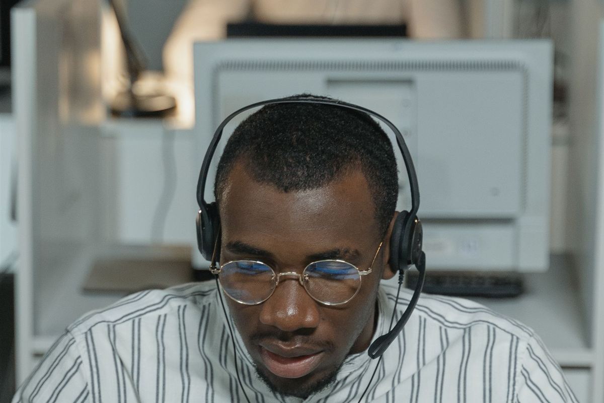 African support technician wearing a headset at his workstation