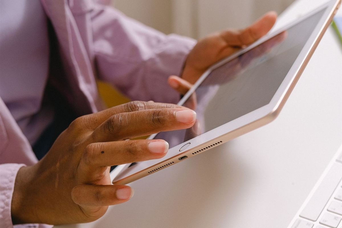 Black woman using a tablet beside a keyboard
