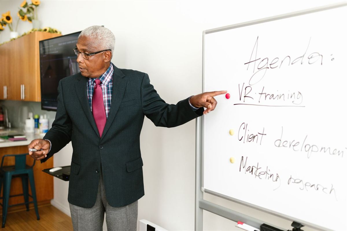Senior African business leader presenting a plan on a whiteboard